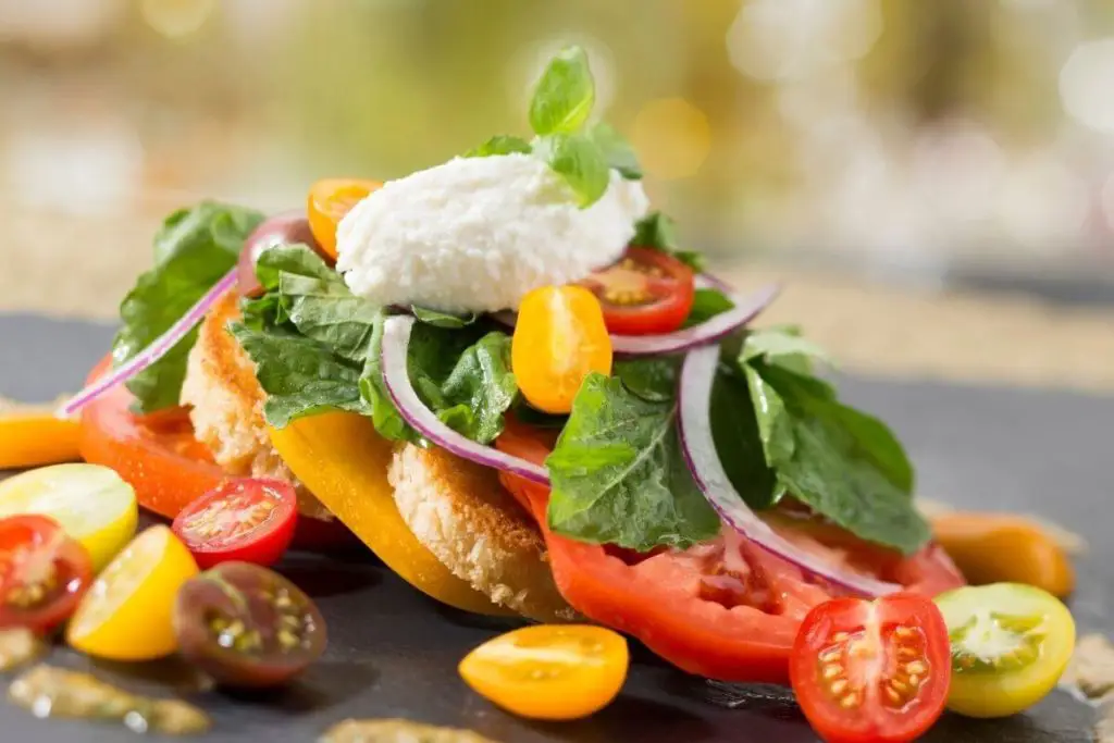 Closeup of a dish from California Grill from Disney World's Contemporary Resort with lots of fresh tomato, basil, and onion.