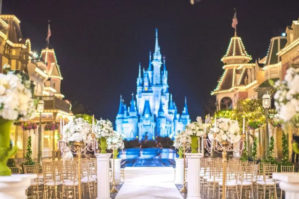 Photo of seating and decor set up for a wedding ceremony with Magic Kingdom's Cinderella's Castle in the background.