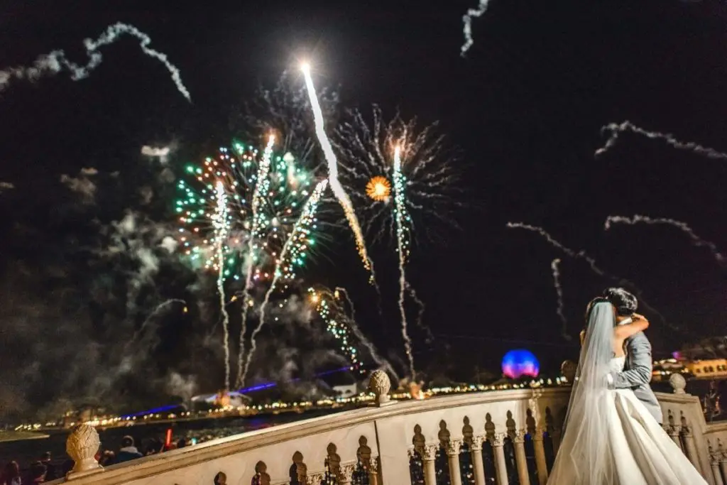 Closeup of a bride and groom embracing while watching Epcot's nighttime show, Epcot Forever.