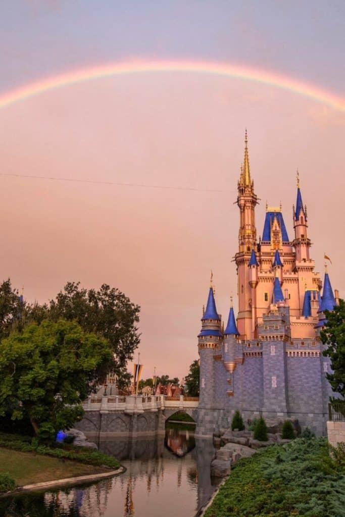 Photo of Cinderella's Castle with grey skies and a rainbow over the castle.