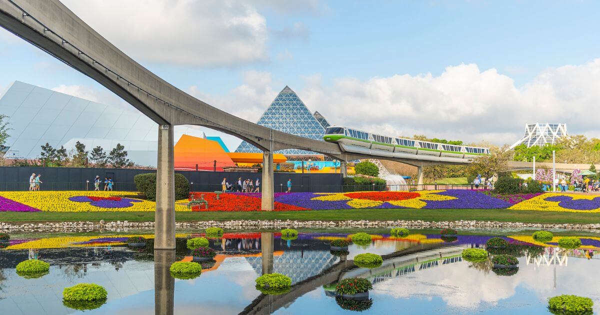Photo of the monorail riding through Epcot with an elaborate floral display below.