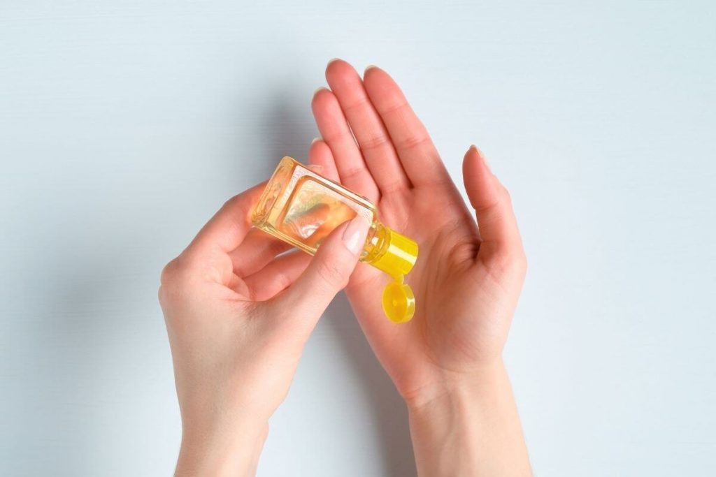 一方が他方に手の消毒剤を注ぐ手の写真。