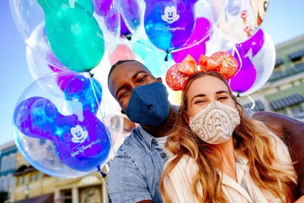 Photo of a man and woman posing with a group of balloons.