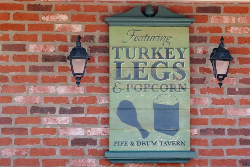 Closeup of a sign that reads "Featuring Turkey Legs & Popcorn: Fife & Drum Tavern."