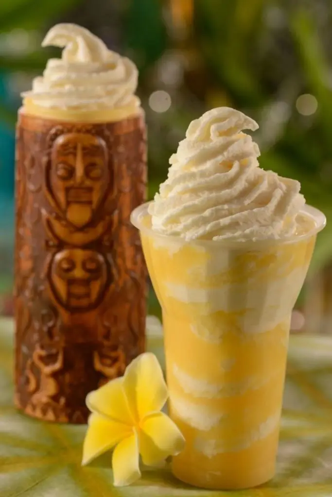 Photo of a pineapple DOLE Whip float and a wooden tiki glass with whipped cream at the top.
