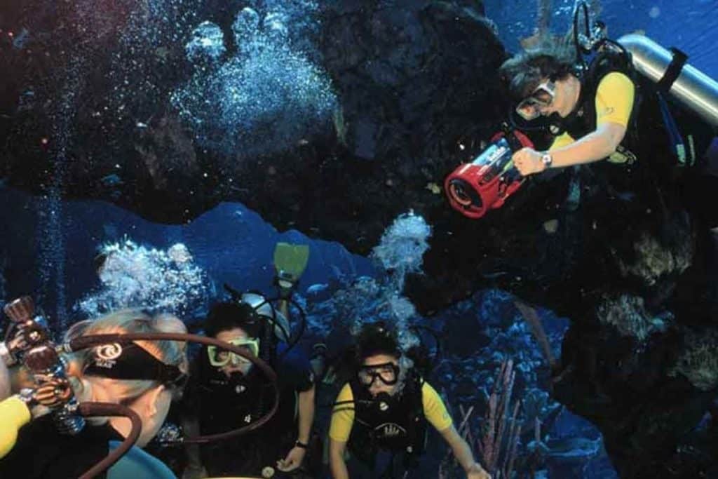 Photo of 4 people scuba diving at the aquarium in Epcot Sea Base.