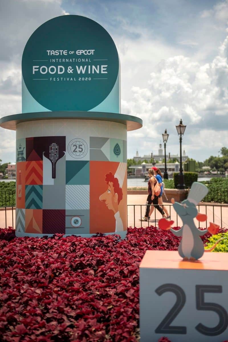 Closeup of the Taste of Epcot Food & Wine Festival sign inside the Epcot theme park with artwork depicting characters from Ratatouille.