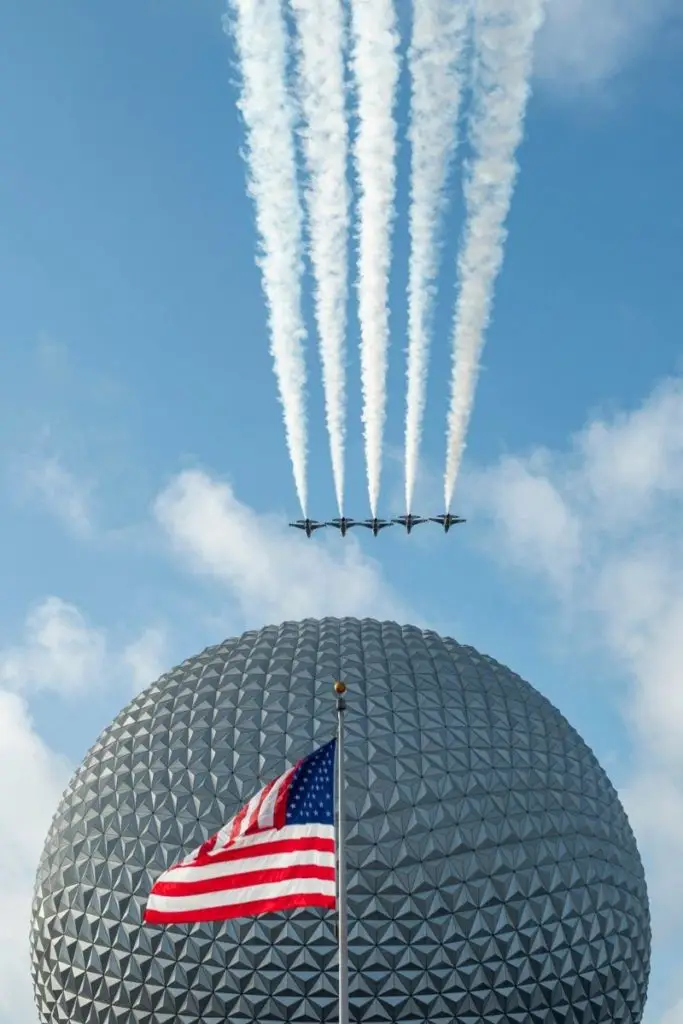 Photo of 5 military jets flying over Spaceship Earth with the American flag in the front at Disney World's Epcot.