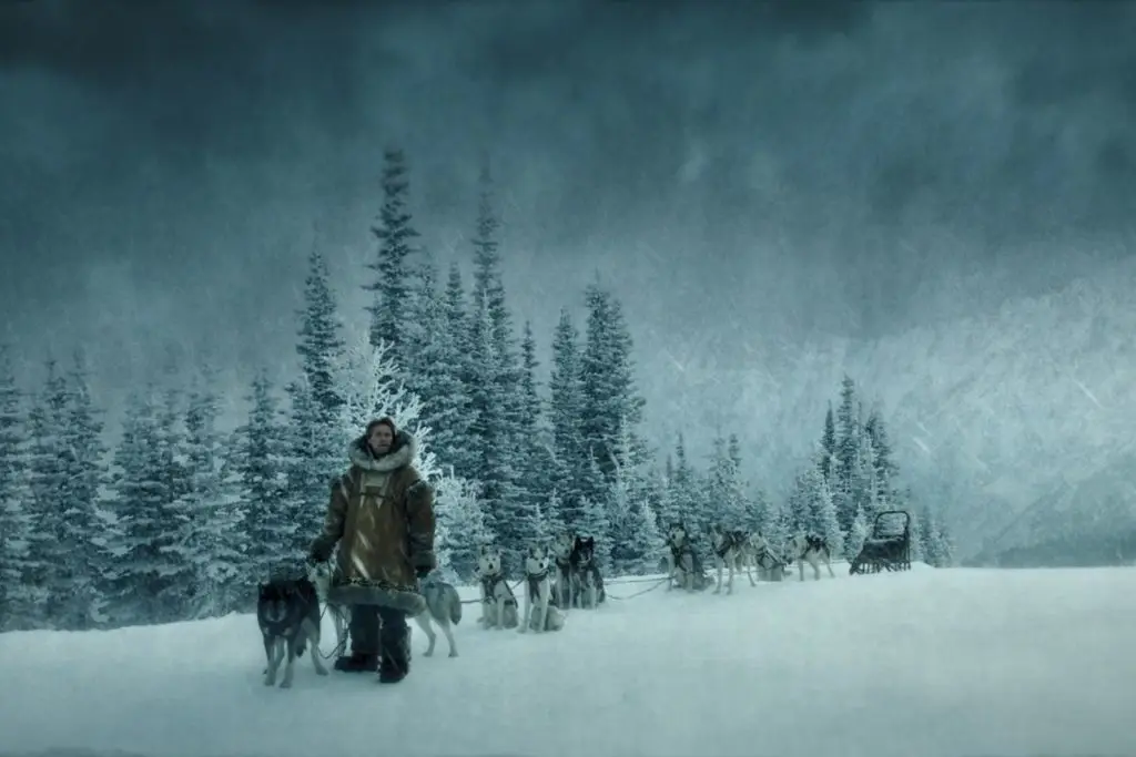Screenshot with a man and about a dozen sled dogs in the snow from one of many dog movies on Disney Plus, Togo.