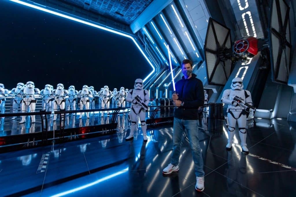 Tom Brady poses with a light saber in front of a group of Stormtroopers at Hollywood Studios' Star Wars: Galaxy's Edge.