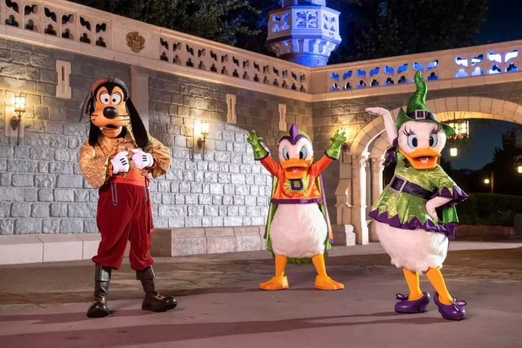 Photo of Goofy, Donald Duck, and Daisy Duck posing at Magic Kingdom while wearing Halloween costumes.