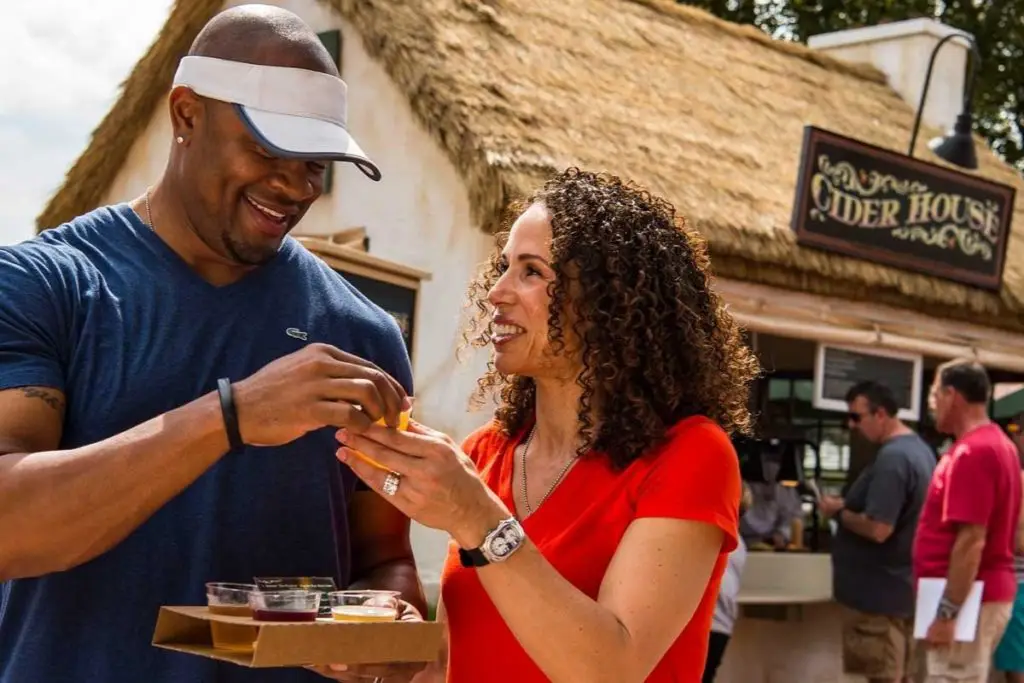 Photo of a couple sampling alcoholic cider from Cider House at the Epcot Food & Wine Festival.