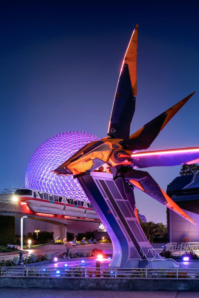 Photo of the Xandarian Starship outside the Guardians of the Galaxy: Cosmic Rewind roller coaster at night with Spaceship Earth and the monorail driving by in the background.