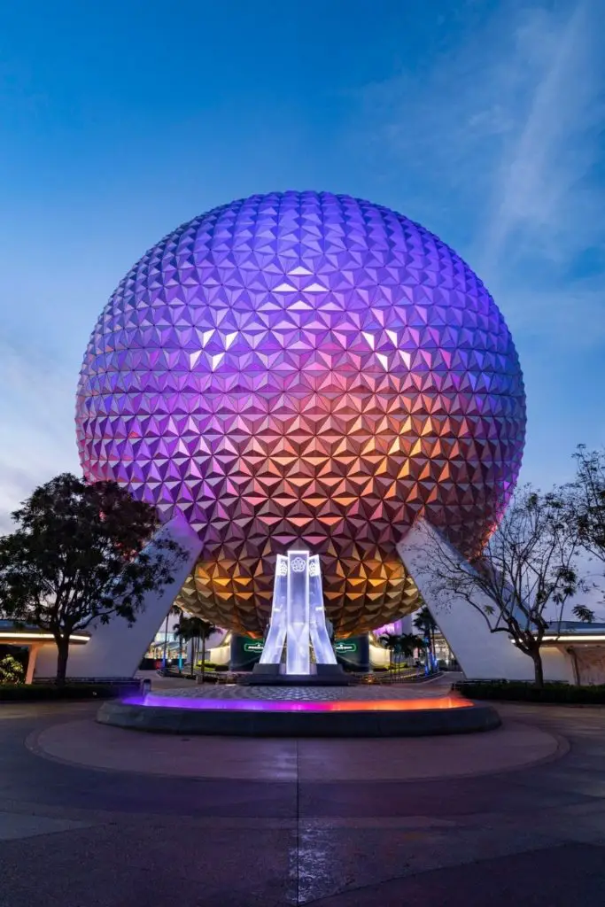 Photo of the Epcot ball light up in purple, blue, and orange.