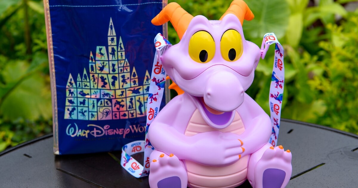 Photo of a Figment popcorn bucket with the Epcot 40th Anniversary themed strap and a Walt Disney World 50th Anniversary reusable shopping tote.
