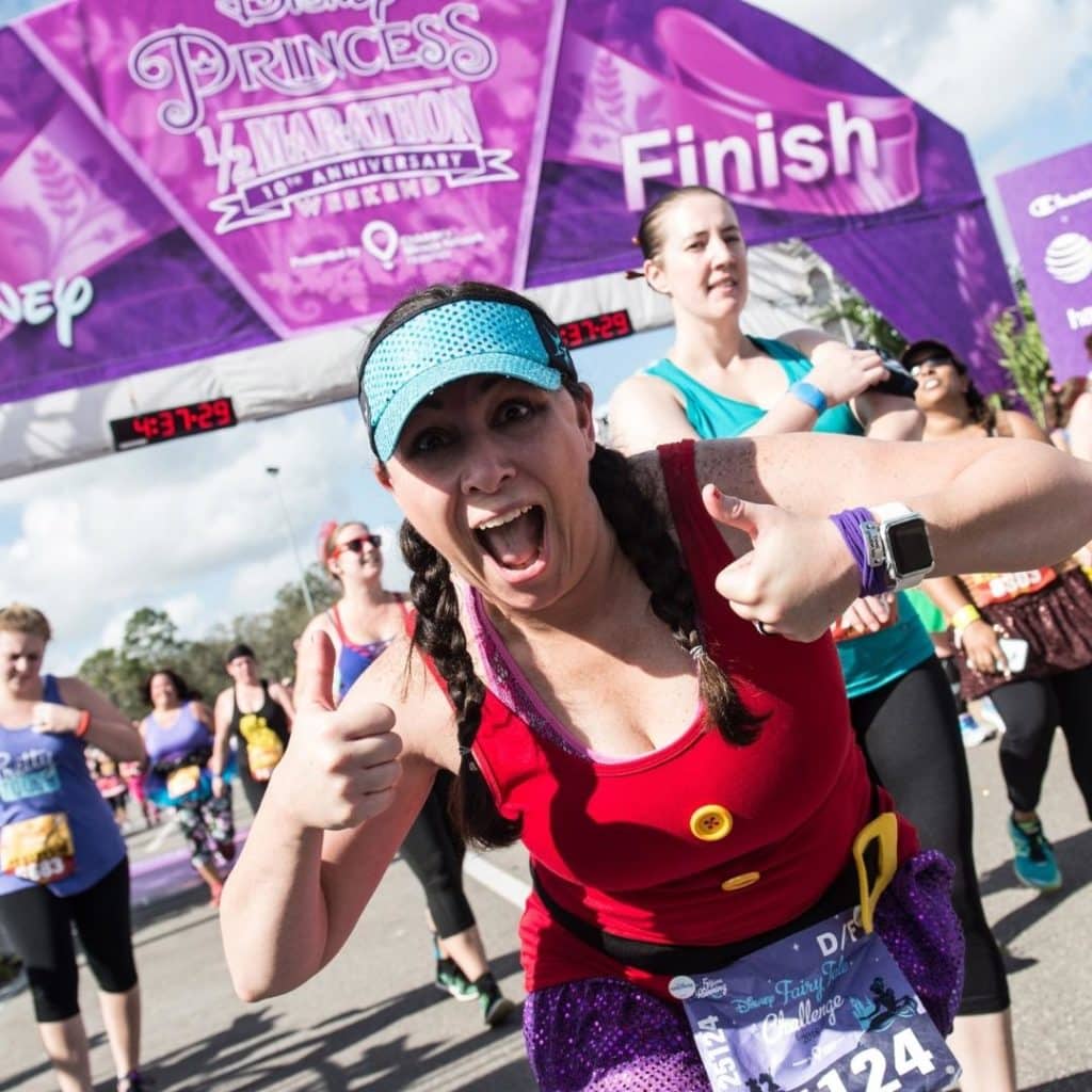 Photo of a woman celebrating crossing the finish line at the Disney Princess Half Marathon at Disney World in February.