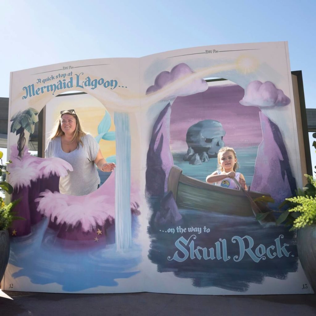 Photo of a mom and daughter posing in a mermaid themed storybook photo op at Epcot Festival of the Arts.
