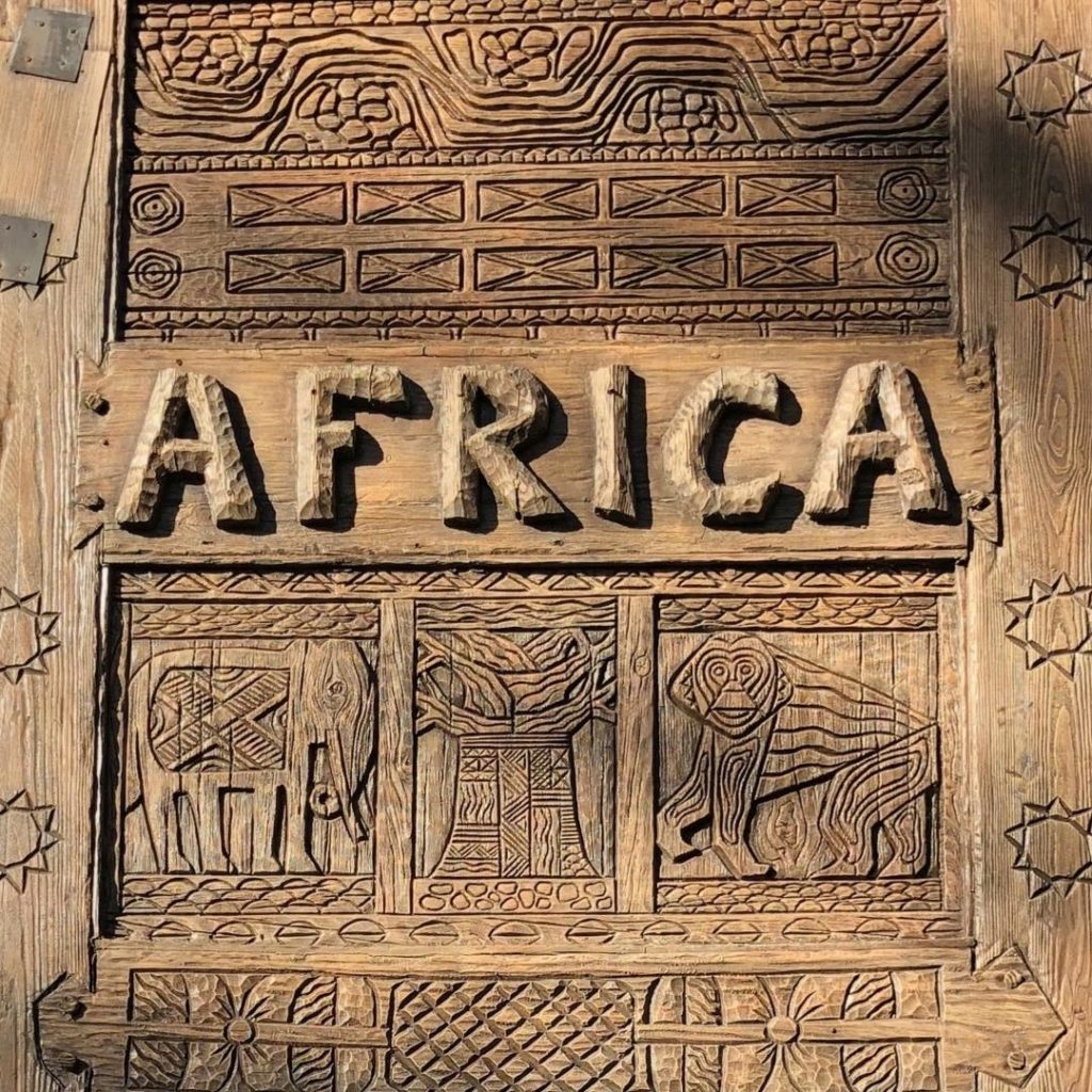 Closeup photo of the giant wooden carved doors outside Animal Kingdom's Africa entrance.