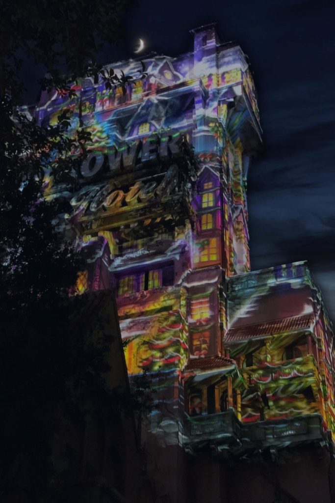 Closeup of The Twilight Zone Tower of Terror building at night with a light show overlay.