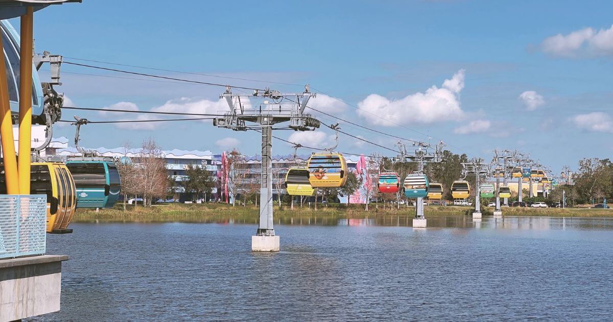 Photo of the Skyliner transportation system running across Hourglass Lake between the Art of Animation and POP Century resorts at Disney World.