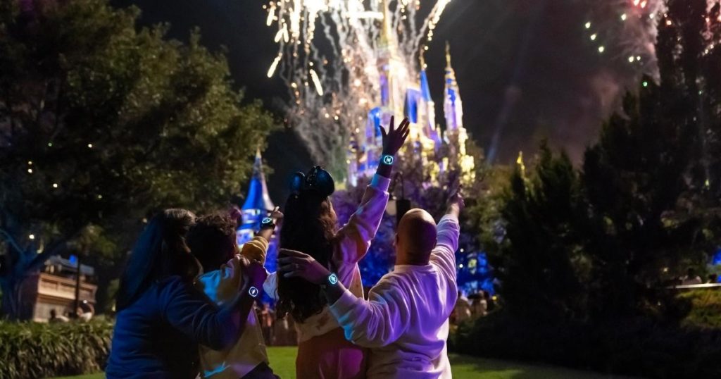 Photo of a family of 4 watching the fireworks at Magic Kingdom.