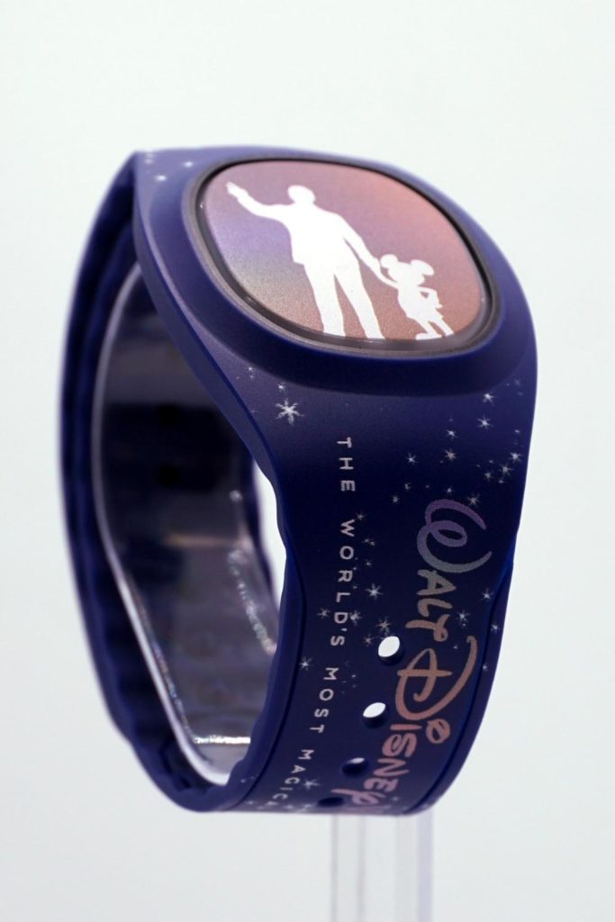 Closeup of a blue Magic Band Plus with a silhouette of Walt and Mickey Mouse in the center.