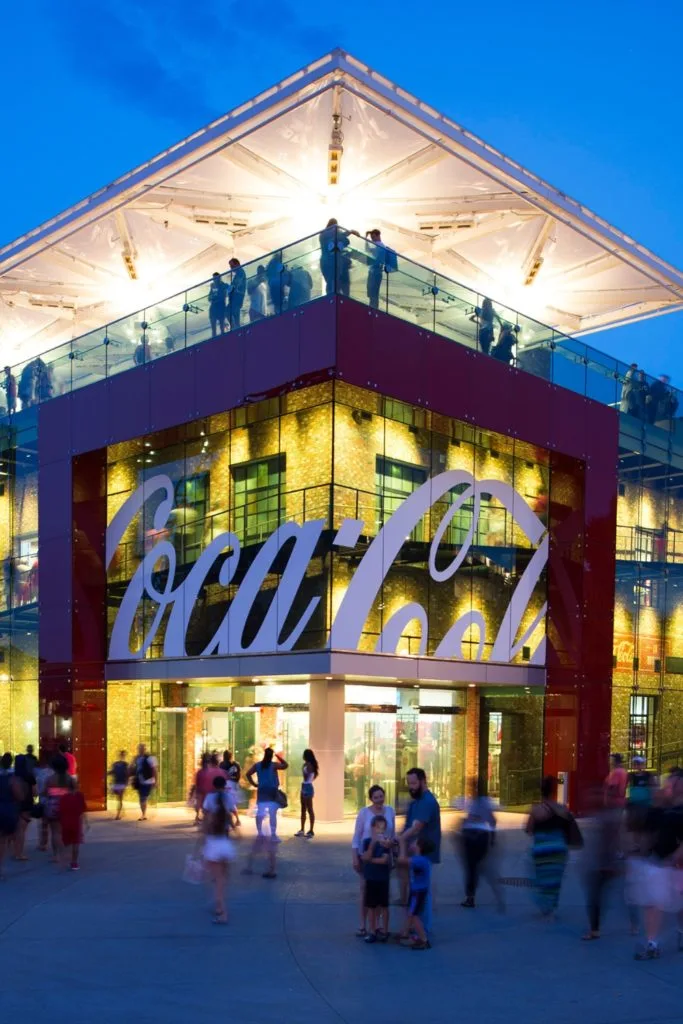 Photo of the Coca Cola store and rooftop bar in Disney Springs at night.