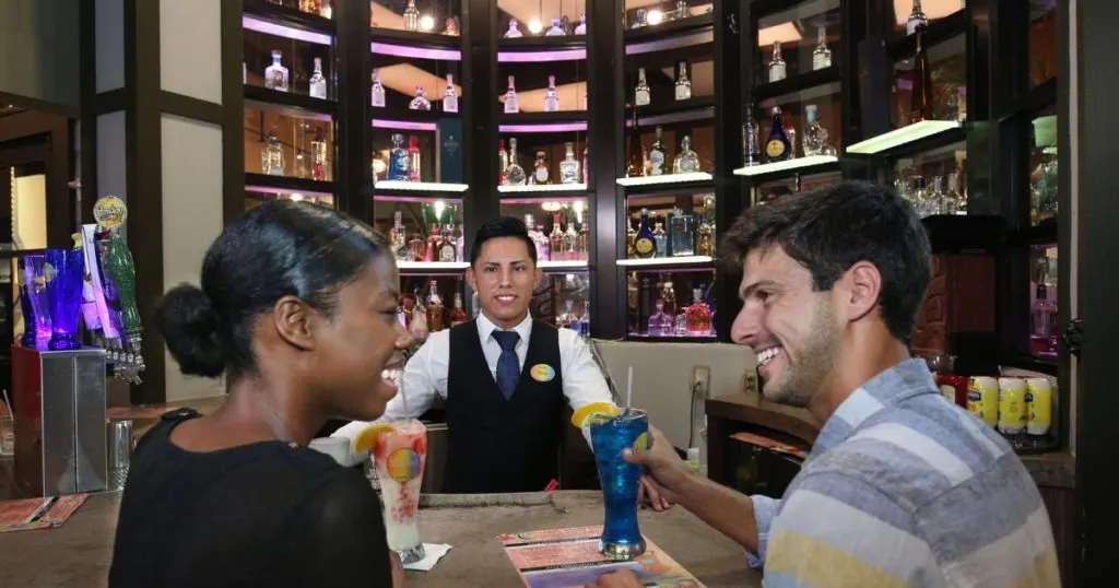 Photo of 2 adults sitting at the bar at Paradiso 37 Entertainment while chatting with the bartender.