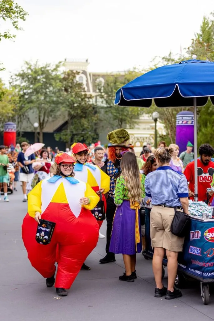 Photo of guests at Mickey's Not-So-Scary Halloween Party at Magic Kingdom, including 2 adults dressed in costume as Tweedle Dee and Tweedle Dum.