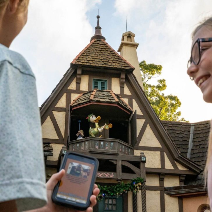 Photo of 2 kids playing DuckTales World Showcase Adventure game at Epcot with the Play Disney Parks mobile app.