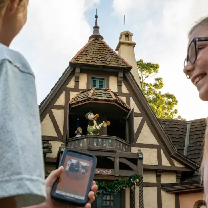 Photo of 2 kids playing DuckTales World Showcase Adventure game at Epcot with the Play Disney Parks mobile app.