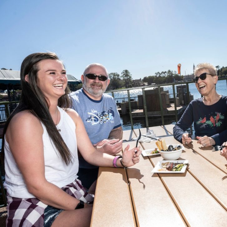 Photo of a group of people enjoying food at a picnic table at Epcot.
