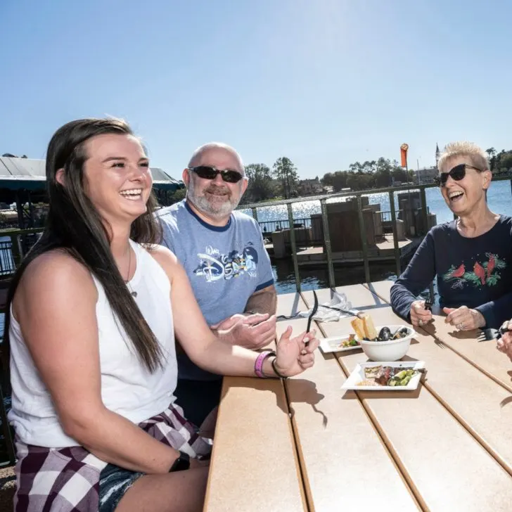 Photo of a group of people enjoying food at a picnic table at Epcot.