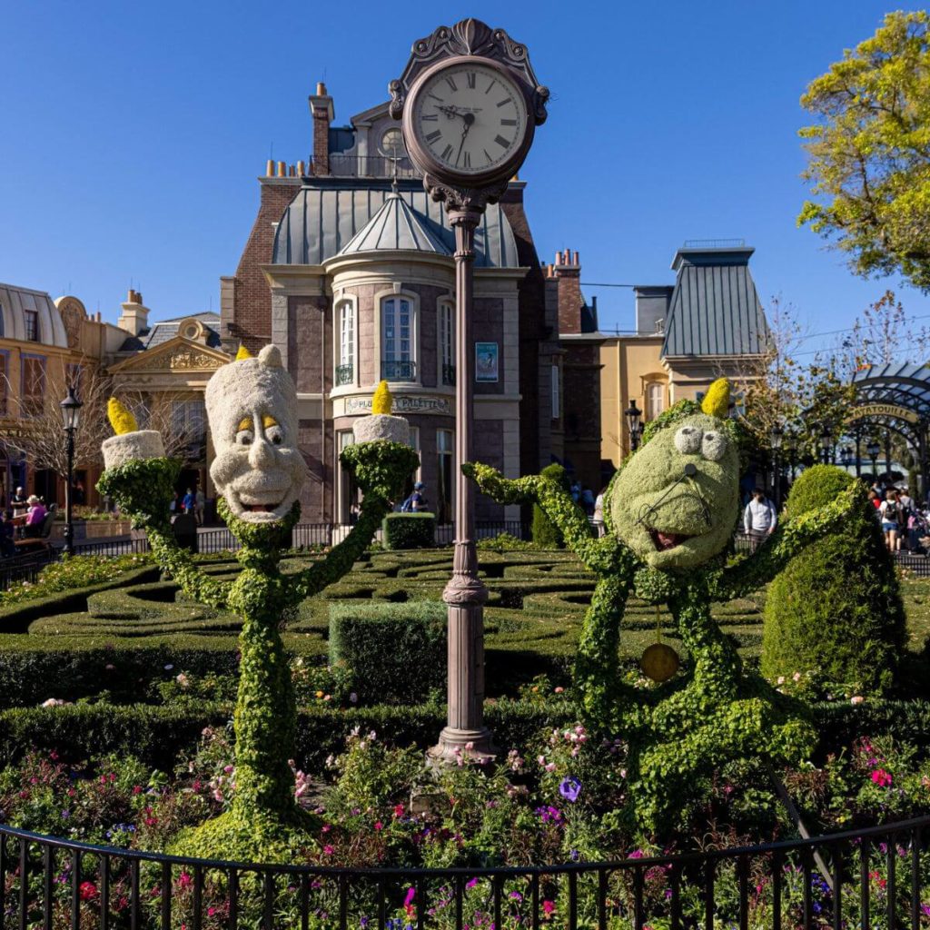Photo of two topiaries designed like Beauty & the Beat's Cogsworth and Lumiere at Disney World's Epcot.