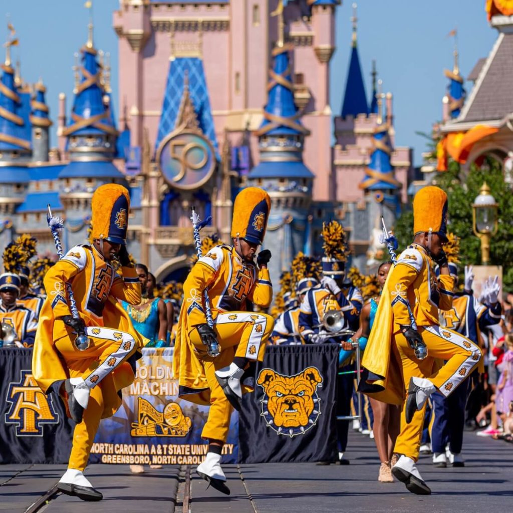 Photo of drum majors leading the marching band from HBCU North Carolina A&T State University in a parade at Magic Kingdom.