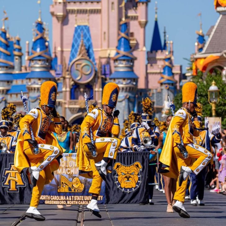 Photo of drum majors leading the marching band from HBCU North Carolina A&T State University in a parade at Magic Kingdom.