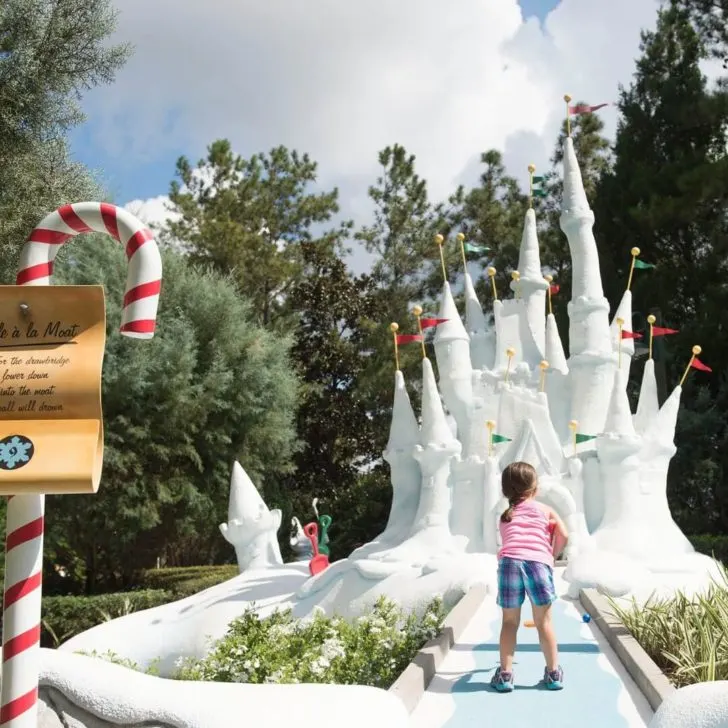 Photo of a young girl playing miniature golf.