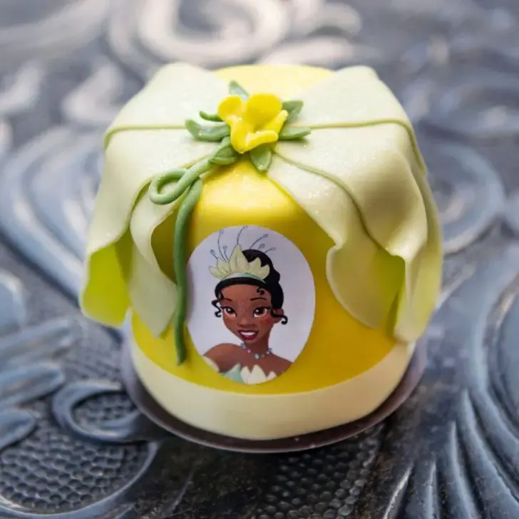 Closeup of a petit cake with a Princess Tiana theme from Amorette's in Disney Springs.