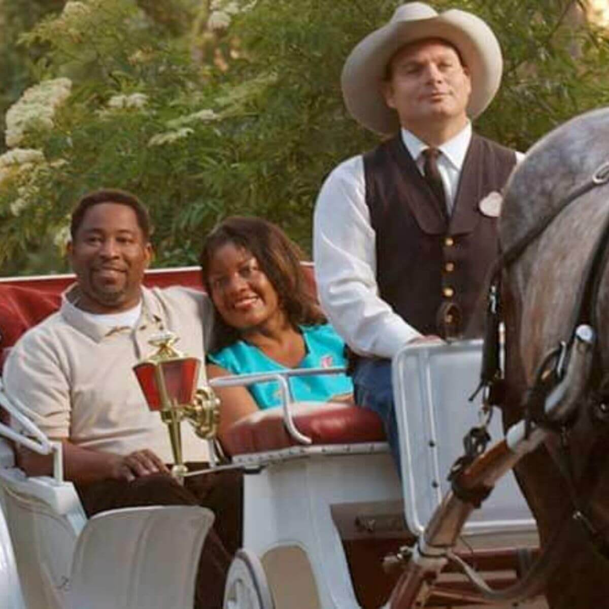 Photo of a man and woman enjoying a horse-drawn carriage ride at Disney World.