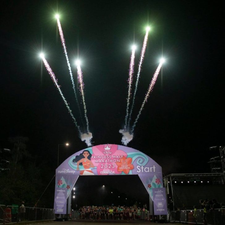 Photo of the start line for the 2023 Princess Half Marathon at Disney World with fireworks going off behind it.