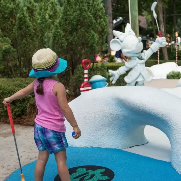 Photo of a young girl playing mini golf at Disney's Winter Summerland Miniature Golf Course.