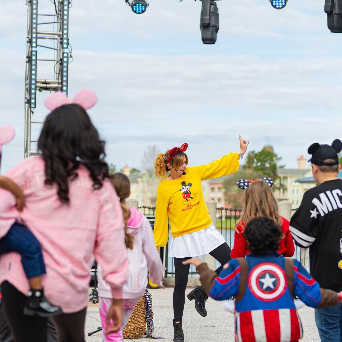 Photo of a singer performing at Disney Springs with families in the crowd.