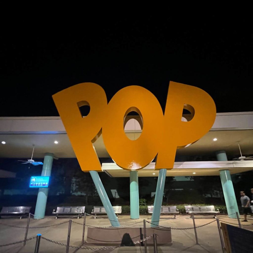 Photo of a giant POP sign at a bus stop in Disney World.