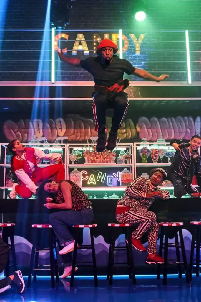 Photo of dancers performing on stage with Stephen "Twitch" Boss jumping in the middle.