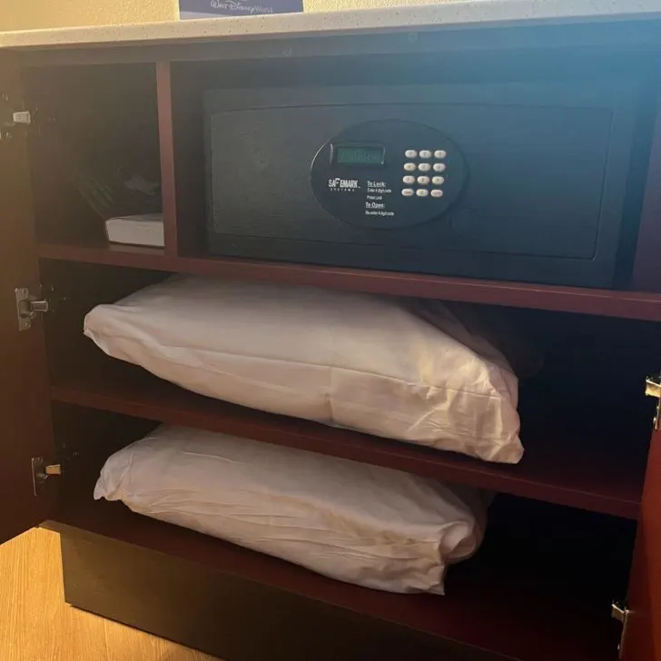 Photo of the hotel rooom safe and extra pillows in a console.