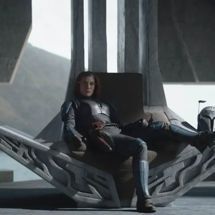 Photo still of a scene with Bo-Katan Kryze (Katee Sackhoff) sulking in her throne in season 3 of Lucasfilm's THE MANDALORIAN.