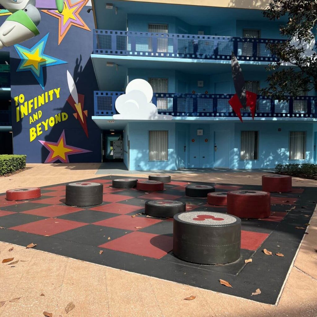 Photo of a life-sized Checkers board, with checkers pieces stacked along the board.