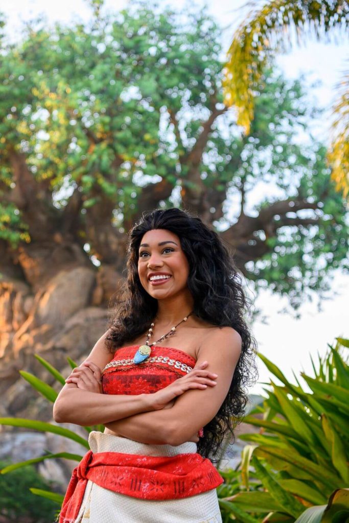 Vertical photo of Moana at Disney World in Animal Kingdom, with the Tree of Life behind her.