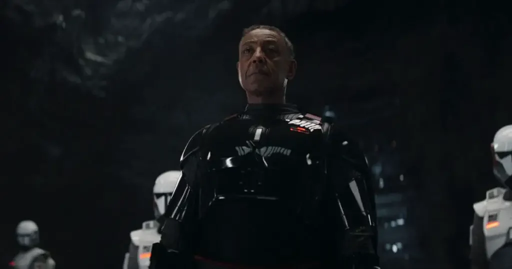 Photo still of a scene from season 3 of The Mandalorian with Moff Gideon (Giancarlo Esposito) in the center with Imperial armored commandos on each side.