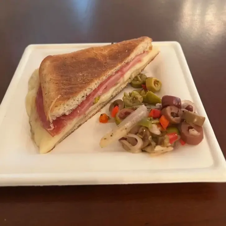 Photo of the Muffuletta sandwich with olive salad from Magnolia Terrace outdoor kitchen.
